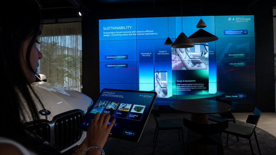 Automotive sustainability showcase with iPad control and large interactive display wall